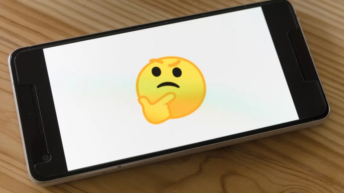 black flat screen tv turned on displaying yellow emoji